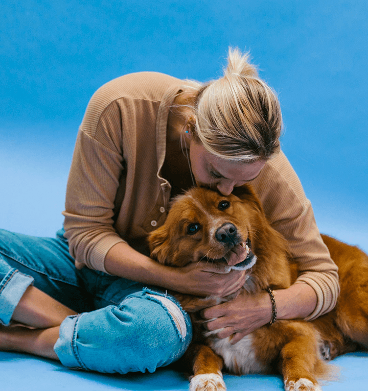 Person hugging a golden retriever dog named Max